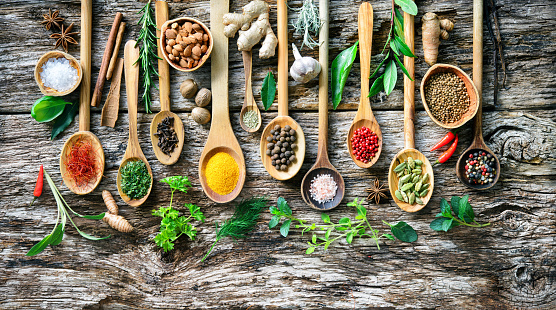 Colourful aromatic various herbs and spices for cooking on old wooden board