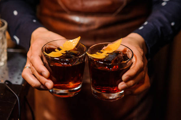 istock Barman holding two glasses filled with alcoholic drink 941859074