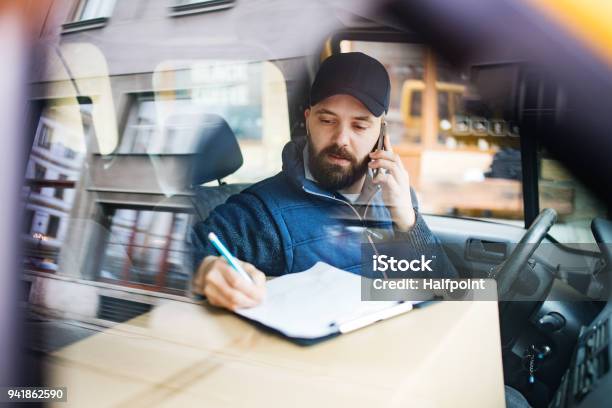 Delivery Man With A Parcel Box In The Car Stock Photo - Download Image Now - Delivery Person, Delivering, Van - Vehicle