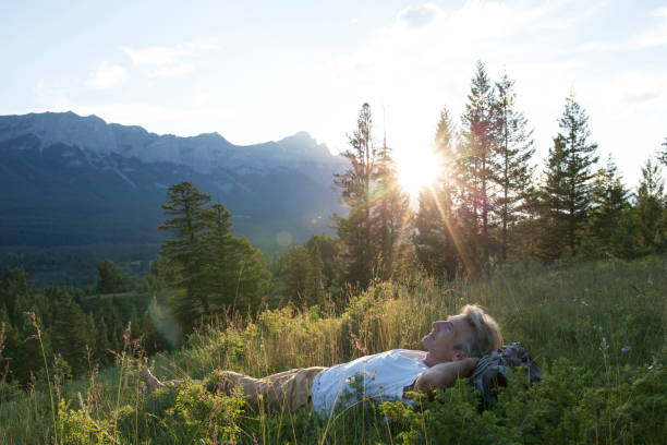 Man lies on back in mountain meadow