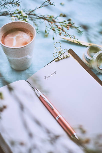 Diary and a cup of coffee on a turquoise napkin