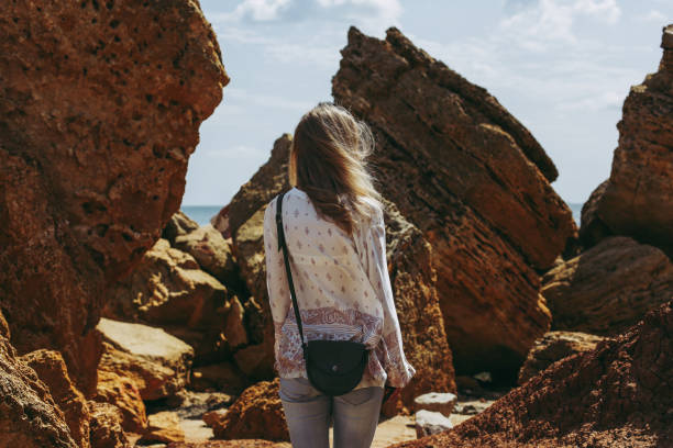 istock Woman among sandstones on seashore 941867278