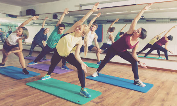 istock men and ladies learning yoga 941870770