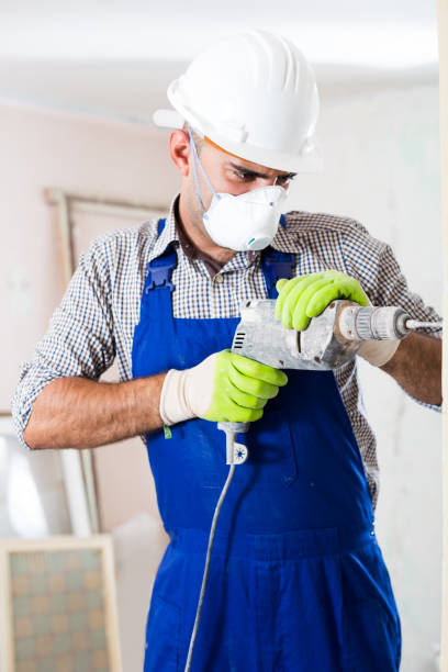 istock Professional worker in helmet is perforating wall with drill 941872330