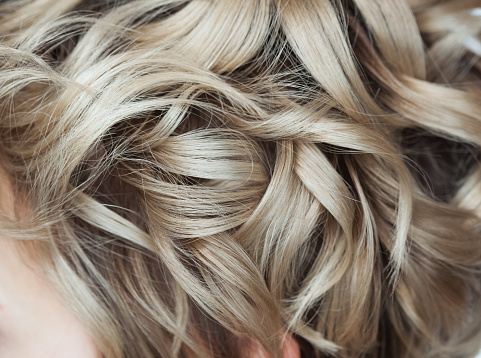 Curly blond hair close-up. Professional hair care.