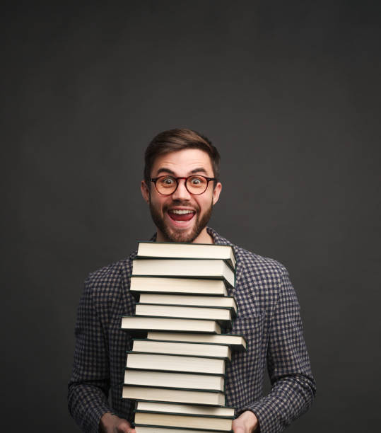 istock Happy man with big stack of books 941874964