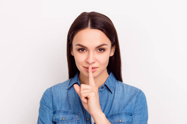 istock Shhh! Cute beautiful girl touch lips with  fingers and keep silence 941876040