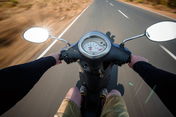 istock Rider driving scooter on an asphalt road. Motion blurred backgro 941878640