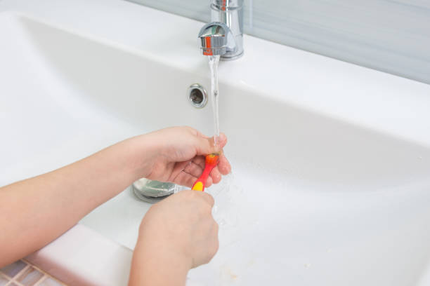 istock Childrens hands wash the toothbrush after brushing their teeth 941879462