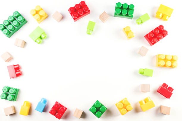 istock Toys background. Colorful wooden cubes and plastic construction blocks frame on white background 941882508