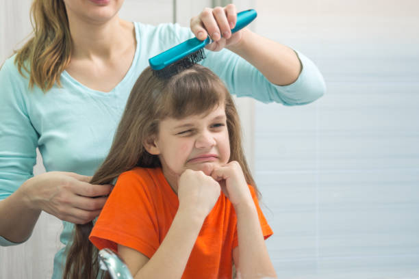 istock The daughter gnaws looking in the mirror while Mom combs her hair 941886108