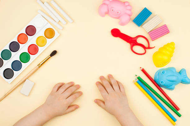 istock the child sits at the table with objects for creativity, drawing and hobbies, the top view 941886264