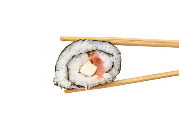 istock Chopsticks holds sushi roll. Isolated on white. 941890194