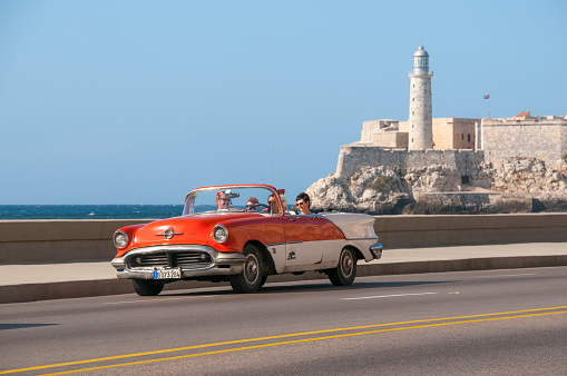 American convertible car on El Malecon avenue in the old Havana transporting tourist on a sunny day. Havana Cuba. May 11 .2015