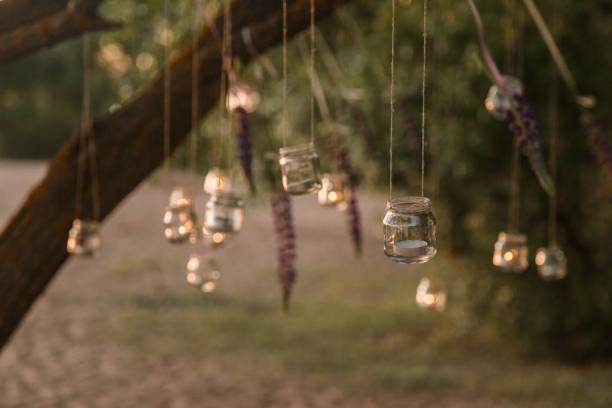 istock mason jar candle hanging on tree for wedding decor 941896558