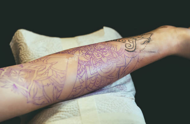 istock Tattoo master protective gloves make a tattoo in black ink on the hand 941900356