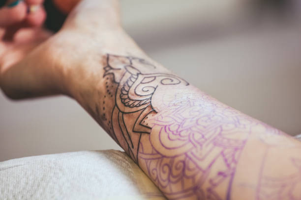 istock Tattoo master protective gloves make a tattoo in black ink on the hand 941900370