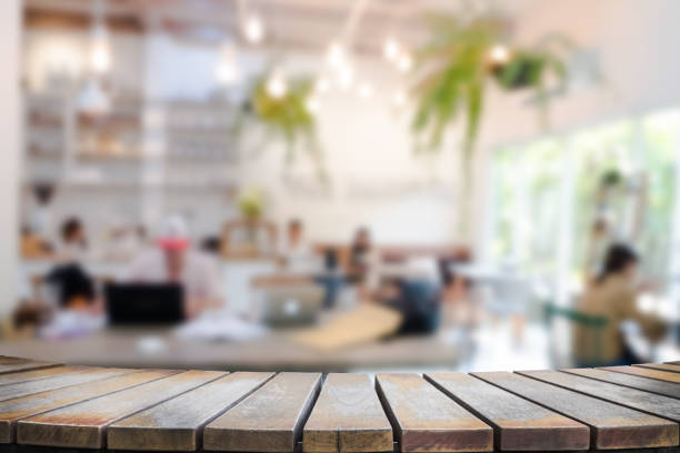 istock Empty wooden table space platform and blurred resturant or coffee shop background for product display montage 941908952
