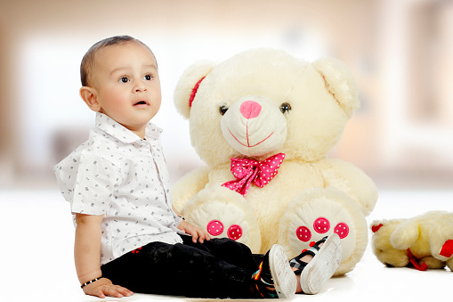 Cute baby with Teddy bear looking away