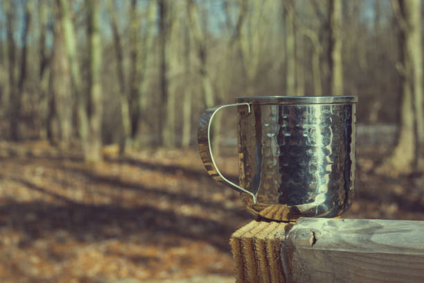 istock textured metal mug in woods on sunny day 941919520