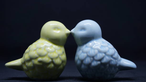 istock Two birds toy kissing each other in the black background. 941925352