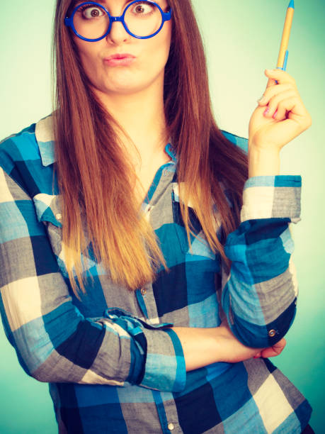 istock Weird nerdy woman in glasses holding pen 941935568