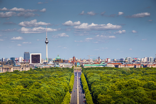 Aerial view of Berlin skyline panorama with Grosser Tiergarten public park on a sunny day with blue sky and clouds in summer seen from famous Berlin Victory Column (Berliner Siegessaeule), Germany