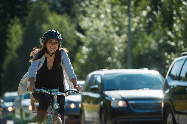 Woman commuting in a cycling lane Woman passing traffic on her bike in a cycling lane cycling stock pictures, royalty-free photos & images
