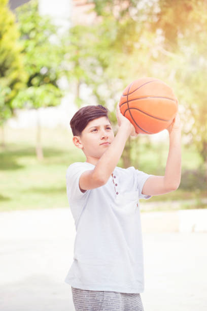 istock Young boy playing basketball 941943928