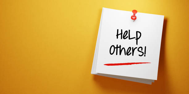 istock White Sticky Note With Help Others Message And Red Push Pin On Yellow Background 941947396