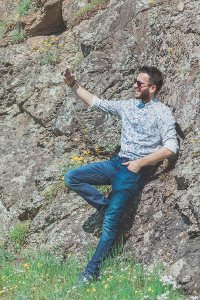 istock Beautiful young man using smartphone in the nature 941949764