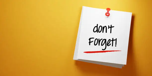 Photo of White Sticky Note With Don't Forget Message And Red Push Pin On Yellow Background