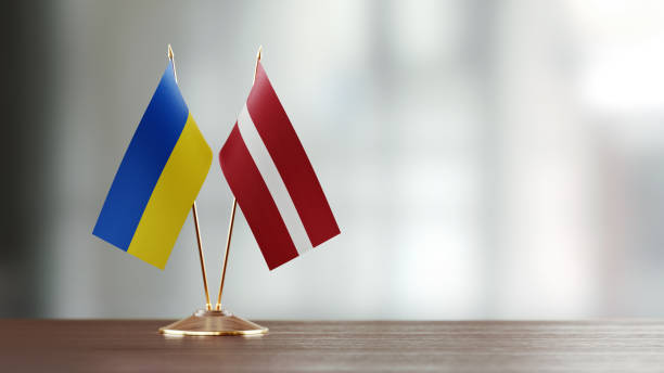 istock Ukrainian And Latvian Flag Pair On A Desk Over Defocused Background 941950478