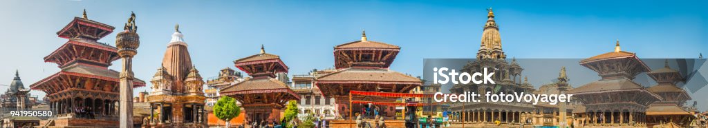 Kathmandu ancient temples and shrines Patan Durbar Square panorama Nepal Clear blue panoramic skies over the wooden temples and shrines as local tourists climb through the historic monuments of Patan Durbar Square, a UNESCO World Heritage Site in the heart of Kathmandu, Nepal's vibrant capital city. Nepal Stock Photo
