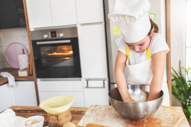 istock Cute young girl baking in home kitchen 941953150