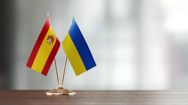 istock Spanish And Ukrainian Flag Pair On A Desk Over Defocused Background 941953586