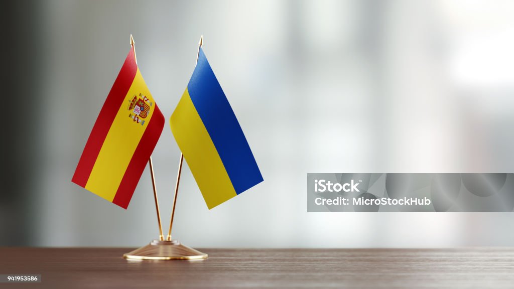 Spanish And Ukrainian Flag Pair On A Desk Over Defocused Background Spanish and Ukrainian flag pair on desk over defocused background. Horizontal composition with copy space and selective focus. Spain Stock Photo Spanish And Ukrainian Flag Pair On A Desk Over Defocused Background Spanish and Ukrainian flag pair on desk over defocused background. Horizontal composition with copy space and selective focus. Spain Stock Photo
