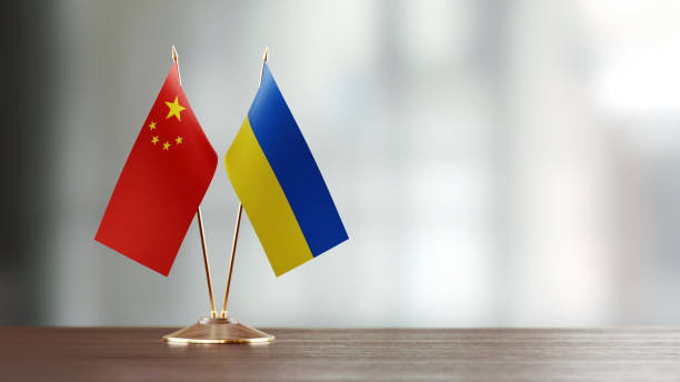 istock Chinese And Ukrainian Flag Pair On A Desk Over Defocused Background 941953770