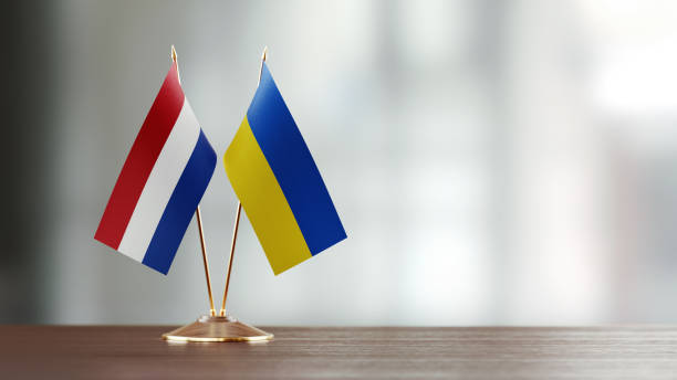 istock Dutch And Ukrainian Flag Pair On A Desk Over Defocused Background 941954344