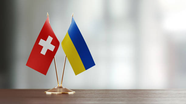 istock Swiss And Ukrainian Flag Pair On A Desk Over Defocused Background 941954872