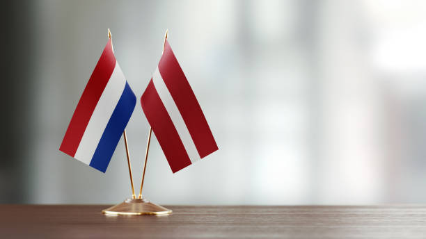 istock Dutch And Latvian Flag Pair On A Desk Over Defocused Background 941955150