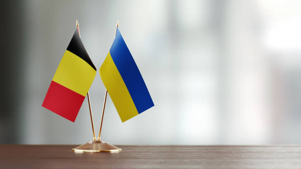istock Belgian And Ukrainian Flag Pair On A Desk Over Defocused Background 941955244