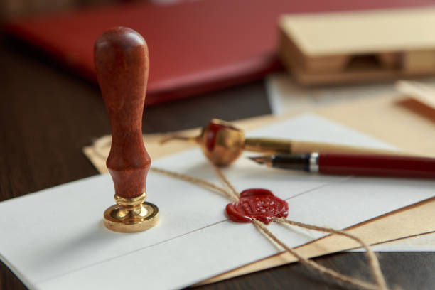 istock Old parchment or diploma scroll with wax seal and quill pen 941961634