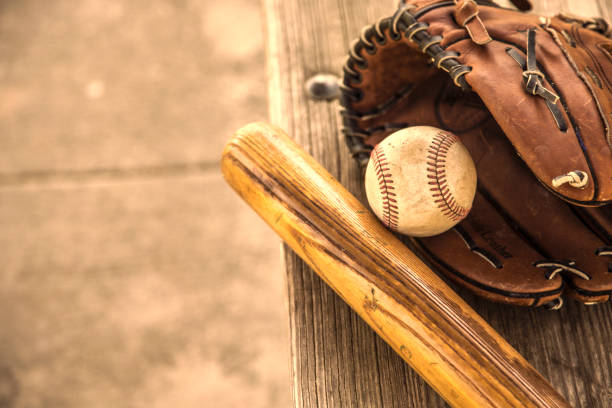 野球のシーズンはここにです。 バット、グローブ、ダッグアウトのベンチ上のボール。 - baseball spring training baseballs sports glove ストックフォトと画像