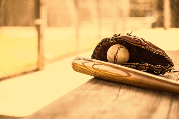 野球のシーズンはここにです。 バット、グローブ、ダッグアウトのベンチ上のボール。 - dugout baseball bench bat ストックフォトと画像