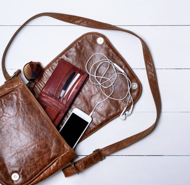 istock open female brown leather bag, a white smartphone 941969852
