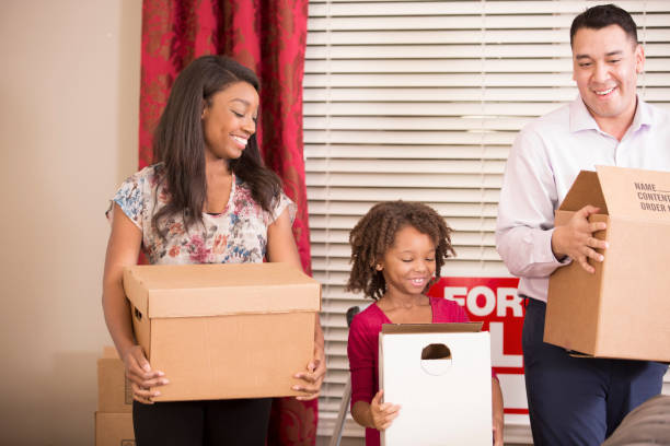 istock Multi-ethnic family packs, unpacks moving boxes in new home. 941972820