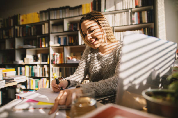 istock Cute satisfied student girl studying in the library for the exam. 941985212