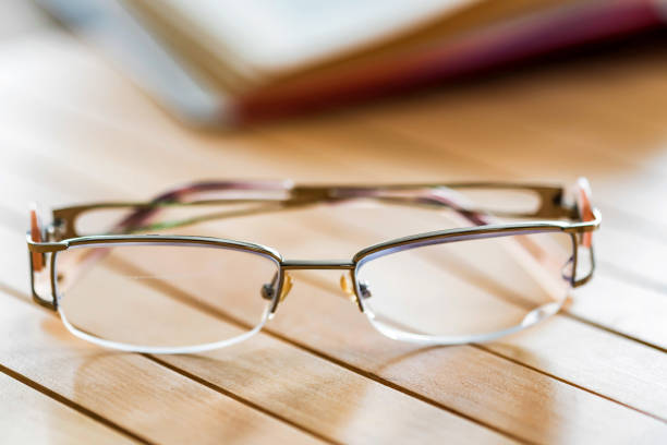 istock Glasses and open book on wooden table close 941998376