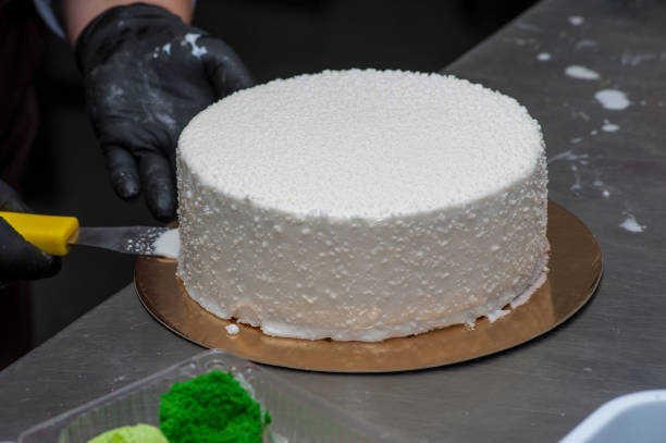 istock Man in black gloves cover cake with glaze 942016714